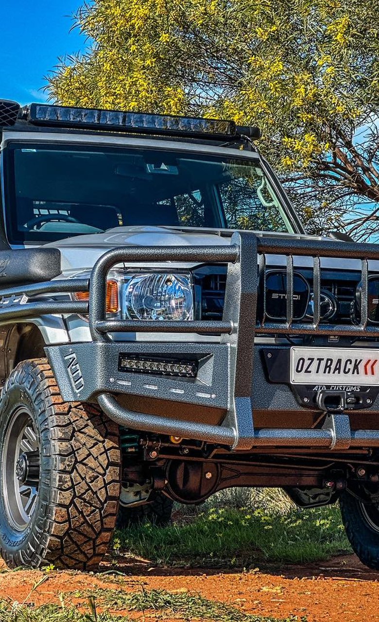 Custom-built OzTrack four-wheel drive with bullbar and light bar on red dirt